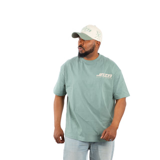 Model trägt grünes JAZA Born To Be Rich T-Shirt im Oversized Streetwear Stil