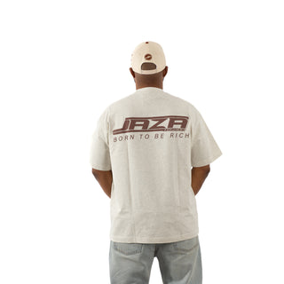 Model zeigt Rückseite eines beigen JAZA Unisex T-Shirts mit großem braunen Rückenprint ‚JAZA – Born To Be Rich‘, vor weißem Hintergrund